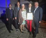 Fünf Personen stehen nebeneinander und präsentieren eine Auszeichnung.